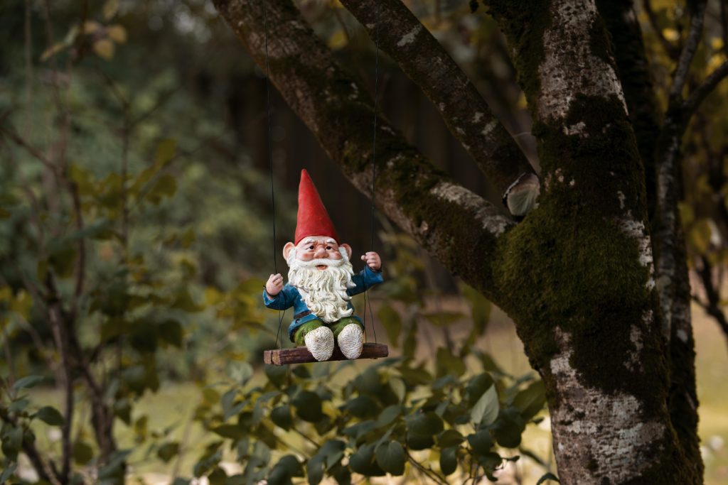 Statua di gnomo nel bosco in un parco naturale del Veneto