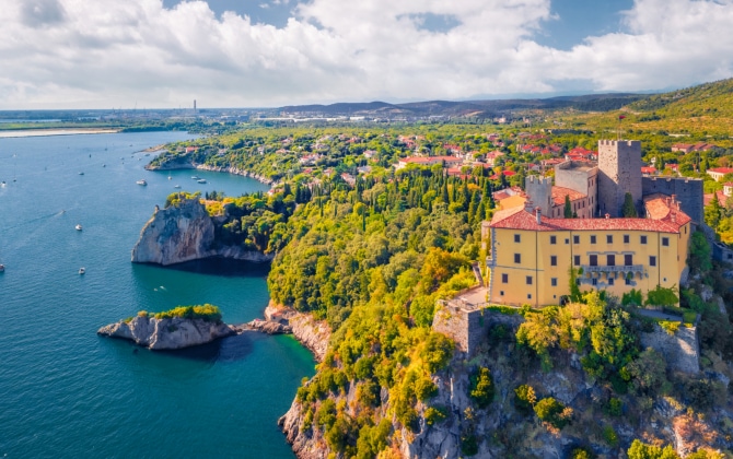 Castello di Duino sul Golfo di Trieste tra alte scogliere, rocce carsiche e barche
