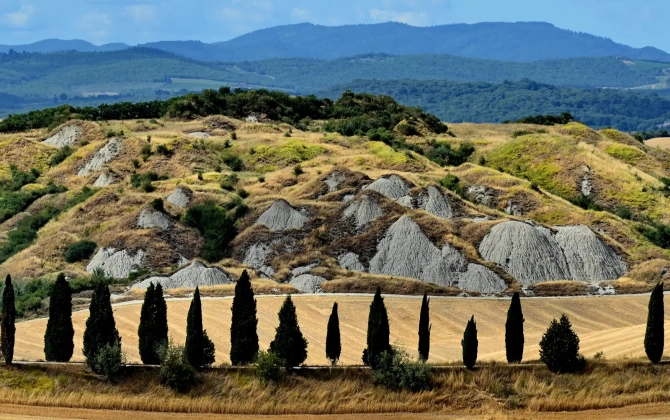 Vista panoramica delle Crete Senesi con cipressi, vicino ad Asciano in provincia di Siena